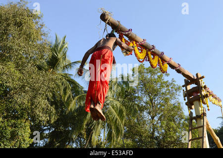 La devota Hindu trafitto da ganci acuti e sollevato dal suolo su una impalcatura utilizzando corde. Foto Stock