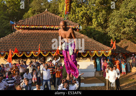 La devota Hindu trafitto da ganci acuti e sollevato dal suolo su una impalcatura utilizzando corde. Konkan, Maharashtra, India Foto Stock