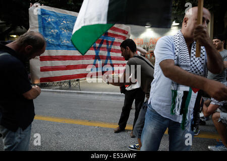 Salonicco, Grecia. 18 Luglio, 2014. Gli attivisti e i palestinesi che vivono in Grecia masterizzare una imitazione della bandiera americana, con una stella di Davide dipinto su di esso di fronte all ambasciata degli Stati Uniti a Salonicco, Grecia il 18 luglio 2014. Credito: Konstantinos Tsakalidis/Alamy Live News Foto Stock