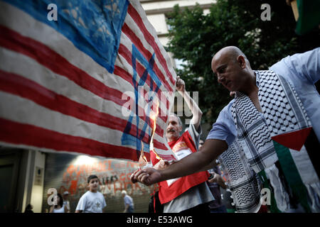 Salonicco, Grecia. 18 Luglio, 2014. Gli attivisti e i palestinesi che vivono in Grecia masterizzare una imitazione della bandiera americana, con una stella di Davide dipinto su di esso di fronte all ambasciata degli Stati Uniti a Salonicco, Grecia il 18 luglio 2014. Credito: Konstantinos Tsakalidis/Alamy Live News Foto Stock