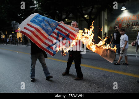 Salonicco, Grecia. 18 Luglio, 2014. Gli attivisti e i palestinesi che vivono in Grecia masterizzare una imitazione della bandiera americana, con una stella di Davide dipinto su di esso di fronte all ambasciata degli Stati Uniti a Salonicco, Grecia il 18 luglio 2014. Credito: Konstantinos Tsakalidis/Alamy Live News Foto Stock