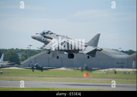 Aerodromo di Farnborough Hampshire, Regno Unito. Il 18 luglio 2014. Il salone aerospaziale internazionale è il Regno Unito il più grande evento nel settore aerospaziale e della difesa, del calendario che si tiene ogni due anni. Harrier Jump jet della Marina spagnola prende il largo con Douglas Dakotas schierate in background, la prima volta che un Harrier ha dimostrato in occasione di un'esibizione aerea nel Regno Unito per molti anni. Credito: Malcolm Park editoriale/Alamy Live News. Foto Stock