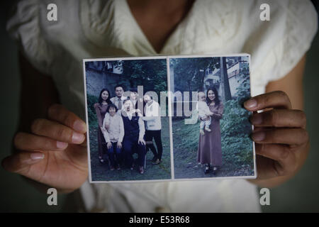 Bangkok, Tailandia. 19 Luglio, 2014. Jiang Kong, il Falun Gong praticante e rifugiato politico dalla Cina mostra una foto di famiglia che è stata adottata nella sua città natale torna in Cina.Il suo padre è stato torturato a morte dalla famigerata bureau 610, in uno dei tanti siti nero in tutta la Cina progettato per fare seguaci di Falun Gong rinunciare alle loro credenze.Il movimento Falun Gong aka Falun Dafa movimento è un movimento vietati in Cina che ha decine di milioni di praticanti in tutto il mondo. Credito: ZUMA Press, Inc./Alamy Live News Foto Stock