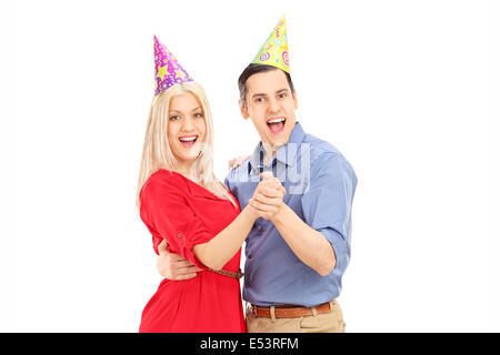 Coppia giovane con party cappelli dancing isolati su sfondo bianco Foto Stock