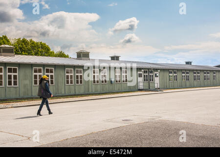 Mauthausen,Austria-May 10,2014:solitario donna con cappello giallo a piedi nella parte anteriore dei prigionieri alle caserme dentro il concentra Foto Stock