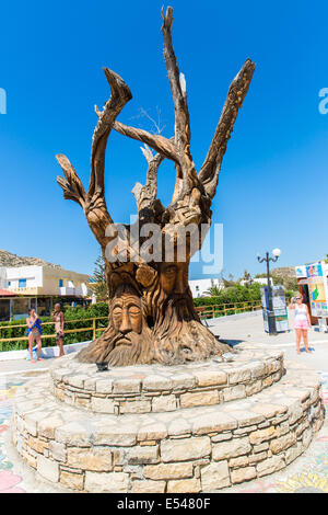 Albero con un volto scolpito sulla piazza di Matala, Grecia Creta. Foto Stock