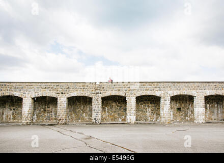 Mauthausen,Austria-May 10,2014:l'uomo sopra la parete interna la di Mauthausen camp in Austria durante un giorno nuvoloso Foto Stock