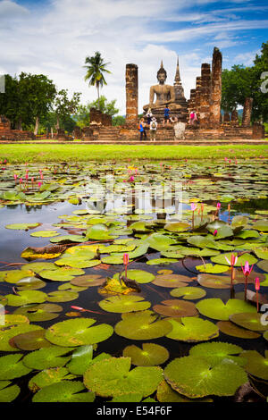 Statua del Buddha e la piscina. Wat Mahathat. Sukhothai Historical Park. Thailandia. Asia Foto Stock
