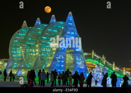 Strutture di ghiaccio al sorgere della luna con la folla di curiosi, International Festival di ghiaccio, Harbin, Cina Foto Stock