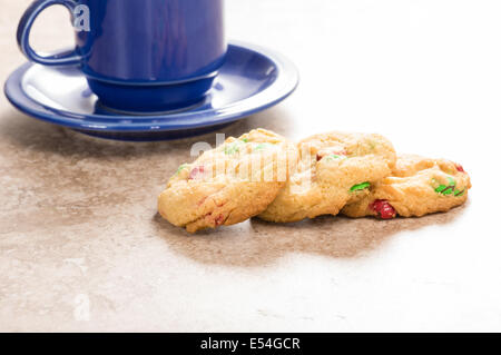 Un blu tazza da caffè con tre biscotti appena sfornati Foto Stock