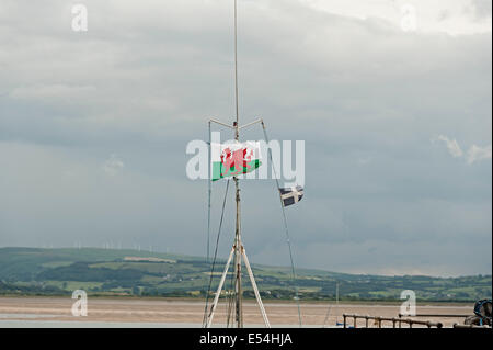 Bandiera gallese battenti in Aberdovey su una barca da pesca con l'estuario in background Foto Stock