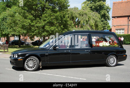 Jaguar funebre trasporta un rosso e bianco bara colorata in un corteo funebre Marlow Buckinghamshire REGNO UNITO Foto Stock