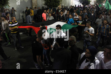 Ramallah, West Bank, Territorio palestinese. 21 Luglio, 2014. Palestinesi chant slogan durante un rally per festeggiare dopo aver udito la notizia del rapimento di un soldato israeliano nella striscia di Gaza e in Cisgiordania città di Ramallah, il 20 luglio 2014. Il Hamas' ala armata ha detto che ha catturato un soldato israeliano nel corso dei combattimenti nella Striscia di Gaza. Parlando a un Hamas stazione televisiva, portavoce Abu Ubaida detto ''Abbiamo catturato un soldato sionista e l'occupazione non ha ammesso che l''. La richiesta potrebbe non essere immediatamente verificata e l'esercito israeliano ha detto che stava esaminando la relazione ( Foto Stock