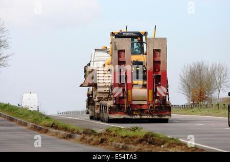 Un articolato caricatore basso portante un bulldozer lungo la A417 a doppia carreggiata in Cotswolds, Inghilterra Foto Stock