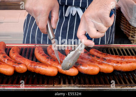 Fornitore di salsicce di cottura su un grill a Southsea food fair festival 2014 England Regno Unito Foto Stock