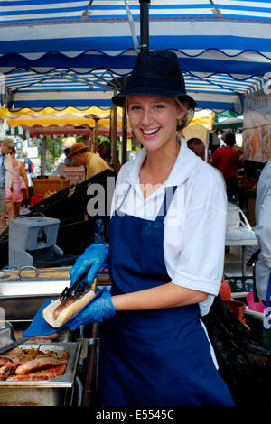 Donna sorridente titolare di stallo la vendita di hot dog a Southsea food fair festival 2014 England Regno Unito Foto Stock
