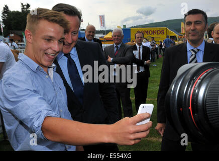 Llanelwydd, Builth Wells, Powys, Wales, Regno Unito. 21 Luglio, 2014. Il Primo Ministro David Cameron si unisce in un selfie con una ventola presso il Royal Welsh Show a Llanelwydd, Builth Wells, Powys. Credito: Barry Bullough/Alamy Live News Foto Stock