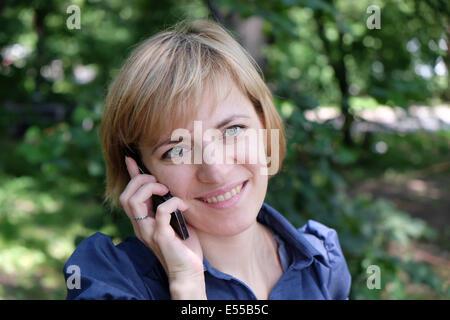 Giovane donna vibrazioni sul telefono cellulare Foto Stock