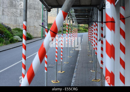 Ponteggio bloccando il marciapiede avvolto in nastro di avvertimento pericolo Foto Stock