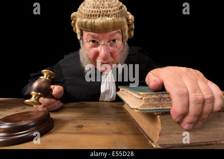 Ampio angolo di ingrandimento di una matura giudice con autentica corte parrucca tenendo un martello in tribunale Foto Stock