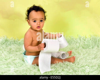 Adorable african baby boy giocando con la carta igienica Foto Stock