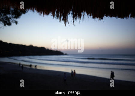 La vista del tramonto in Echo Beach, Bali, da sotto la palapa. Foto Stock