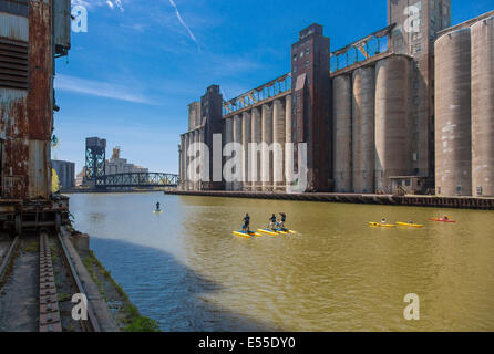 Paddleboarding e kayak in Buffalo fiume lungo lo storico abbandonato elevatori della granella sul lungomare di Buffalo, New York Foto Stock