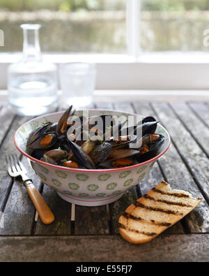 moules mariniere su rustico tavolo in legno stile bistro in finestra Foto Stock