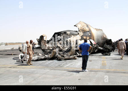 Tripoli, Libia. 21 Luglio, 2014. Alcuni membri del personale della Libia il ministero dei Trasporti ha controllare il relitto di un aereo a Tripoli Aeroporto Internazionale, la Libia, il 21 luglio 2014. L'aeroporto è stata costantemente sotto attacco dai combattenti islamisti dal luglio 13 con la morte pedaggio raggiungendo 47. Credito: Hamza Turkia/Xinhua/Alamy Live News Foto Stock