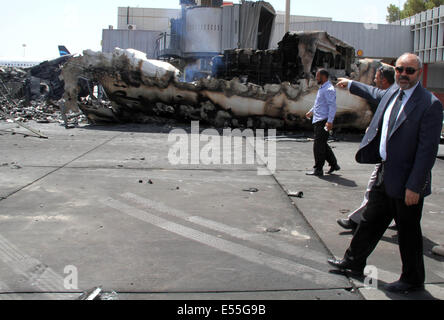 Tripoli, Libia. 21 Luglio, 2014. Libia il Ministro dei trasporti Abdul Qader Mohammed Ahmed Al-Ayib(R) punti al danneggiato aereo a Tripoli Aeroporto Internazionale, la Libia, il 21 luglio 2014. L'aeroporto è stata costantemente sotto attacco dai combattenti islamisti dal luglio 13 con la morte pedaggio raggiungendo 47. Credito: Hamza Turkia/Xinhua/Alamy Live News Foto Stock