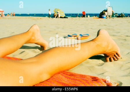 Giovane uomo disteso su un asciugamano sulla spiaggia Foto Stock