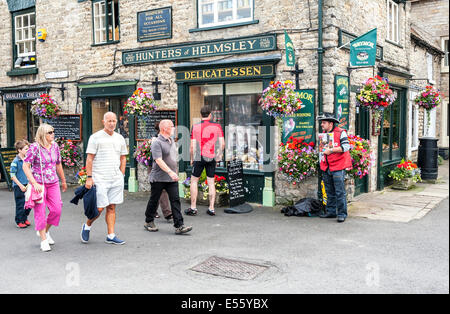 Gli acquirenti e i turisti al di fuori di cacciatori delicatessen in Helmsley market place Foto Stock