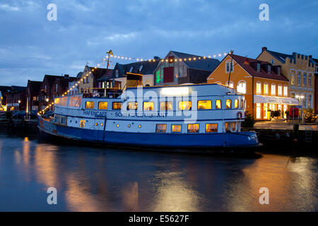 Porto di Husum con una barca ristorante durante le ore di colore blu, Frisia settentrionale, Husum, Schleswig-Holstein, Germania, Europa Foto Stock