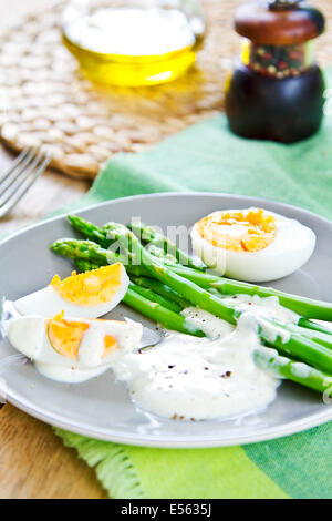 Cotto a vapore gli Asparagi con uova sode e panna acida medicazione Foto Stock