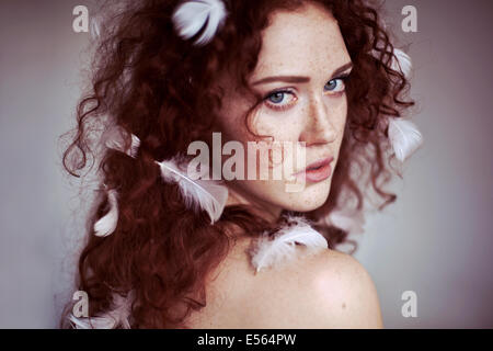 Giovane donna con piume e i suoi capelli Foto Stock