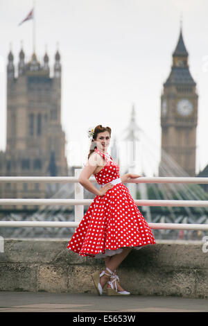 Donna in rosso brillante polka dot dress sul terrapieno di fronte al Big Ben Foto Stock