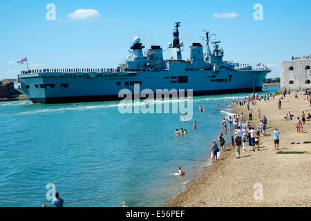 Una folla di popolo patriottico si sono riuniti per guardare il dispositivo HMS illustre immettere portsmouth porto per il tempo finale sotto il bianco alfiere Foto Stock