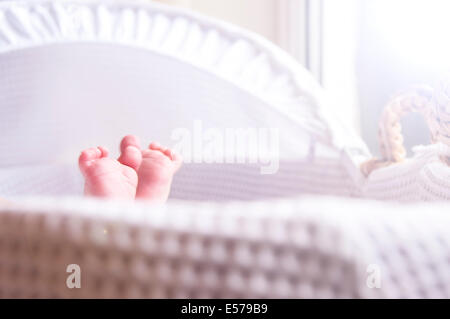 Neonato stirando in una luminosa e ariosa e vivaio cesto di Mosè Foto Stock