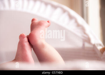 Neonato stirando in una luminosa e ariosa e vivaio cesto di Mosè Foto Stock