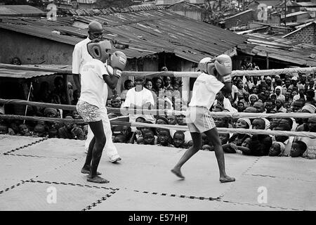 Agosto 31, 2013 - Kampala, Uganda - Kids Boxe a Rhino Boxing Club durante un evento di inscatolamento. Il Katanga a Kampala è una delle baraccopoli comunità dove più di 20.000 persone vivono in condizioni di estrema povertà e senza le infrastrutture di base come ad esempio permanente di acqua fresca di alimentazione e case in mattoni, nel mezzo di shanty case un gruppo di ambiziosi combattenti stanno cercando di raggiungere per una vita migliore. Mentre la raccolta di bucce di banana per sopravvivere, sono appassionato di pugilato, e continuano la loro lotta nonostante il disprezzo che spesso viene pronunciato apertamente. Il Rhino Boxer Club nel bel mezzo della baraccopoli o Foto Stock