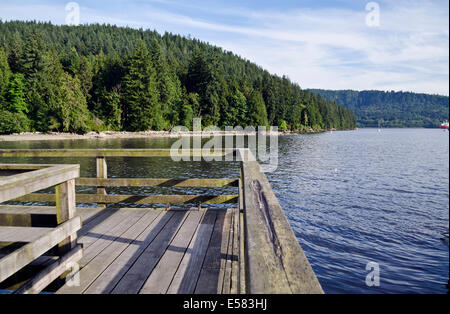 Il molo di legno che si affaccia su acque di Burrard ingresso e foresta di Belcarra Parco Regionale in maggiore di Vancouver. Foto Stock