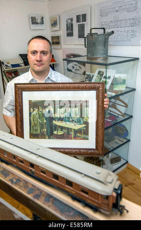 Crawinkel, Germania. Il 18 giugno, 2014. Presidente della società "Alte Muehle" (lit. old mill), Klaus-Peter Schambach, presenta la collezione di fotografie storiche e i resti del leggendario "Carro di Compiegne' presso il museo in Crawinkel, Germania, 18 giugno 2014. La carrozza ferroviaria, in cui il primo e il secondo armistizio di Compiègne sono stati firmati, fu distrutto in Crawinkel negli ultimi giorni della Seconda Guerra Mondiale. Foto: Michael Reichel/dpa/Alamy Live News Foto Stock