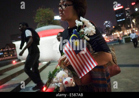 Kuala Lumpur, 22 luglio, 2014. Gli amici di MH17 Membri di equipaggio tenere un fiore durante una vigilia di Kuala Lumpur in Malesia. Malaysia Airlines MH17 era in viaggio da Amsterdam a Kuala Lumpur quando si è schiantato uccidendo tutti 298 sul bordo di cui 80 bambini. Il velivolo è stato presumibilmente abbattuto da un missile e continuano le indagini sugli autori dell'attacco. Credito: Khairil Safwan/Pacific Press/Alamy Live News Foto Stock