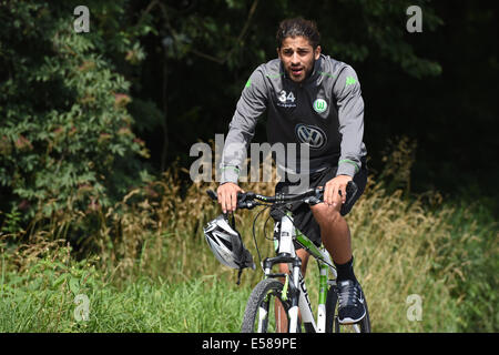 Ricardo Rodriguez della Bundesliga club di calcio VfL Wolfsburg cavalca la sua bicicletta in albergo dopo una sessione di allenamento presso il campo di addestramento a Bad Ragaz, Svizzera, 23 luglio 2014. Foto: FELIX KAESTLE/dpa Foto Stock