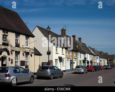 Auto parcheggiate in strada con terrazze cottage in pietra in Cricklade, Wiltshire, Inghilterra, Regno Unito. Foto Stock