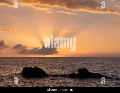 Oceano vulcanica rocce al tramonto, Negril, Giamaica Foto Stock