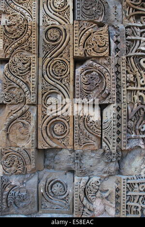 Qutab Minar. La moschea,.Delhi,.L'India. La moschea con ornamenti indù rubato da templi indù. Scultura in pietra arenaria dettaglio. Foto Stock