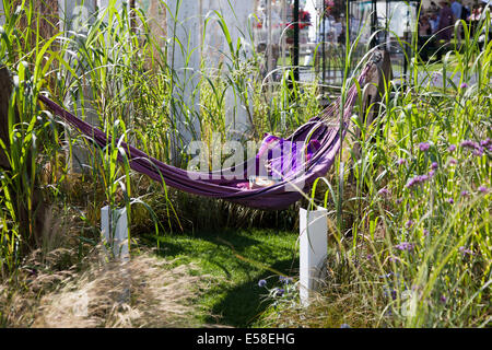 Sedia da sospensione viola con cuscini al Tatton Park, Manchester, Regno Unito. 23 luglio 2014. "A Summer Breeze" ha progettato il piccolo giardino "Clive Scott" con mobili da esterno all'evento RHS - Royal Horticultural Society al Tatton Park. Situato in magnifici parchi, il RHS Flower Show Tatton Park è una celebrazione del meglio in giardinaggio con un'atmosfera vibrante. Foto Stock