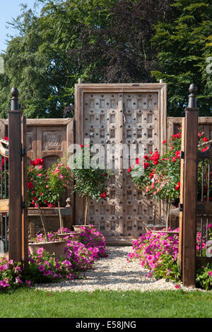 Porte da giardino in legno intagliate con borchie di design e recinzioni alte al Tatton Park, Manchester, Regno Unito. Luglio, 2014. Four Oaks Nurseries 'Summer Dream' al RHS - evento a tema carnevale della Royal Horticultural Society al Tatton Park. Situato in magnifici parchi, il RHS Flower Show Tatton Park è una celebrazione del meglio nel design del giardinaggio Foto Stock