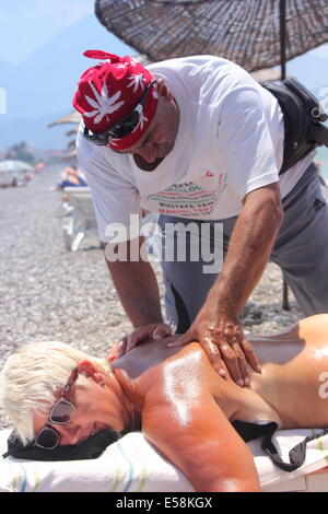 Massaggiatore dando un massaggio completo di una bella donna matura Foto Stock